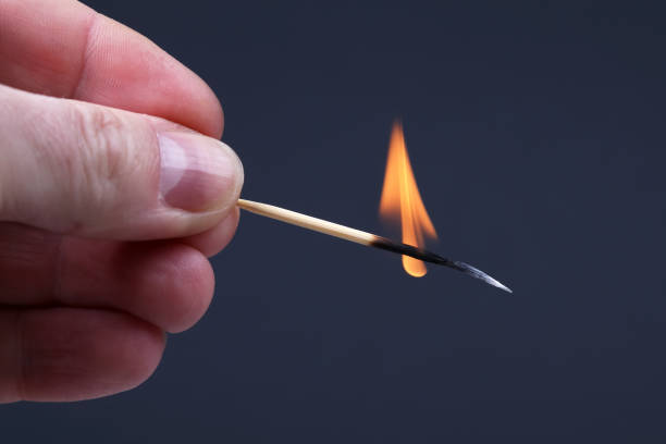 istock burning wooden match on dark background 1127246736