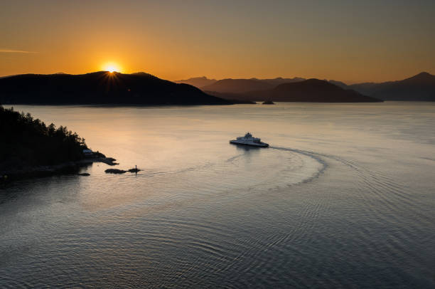 istock Sunset over the mountains with a ferry sailing in the ocean 1127248971