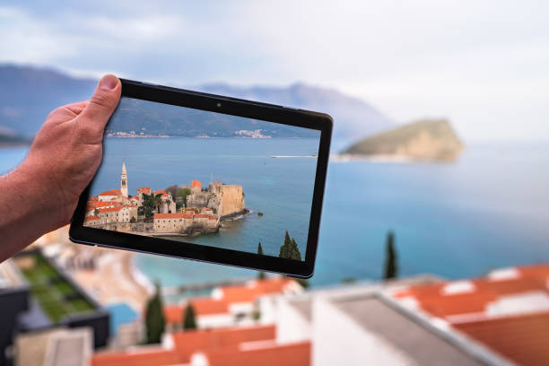 istock Man holding tablet with the image of Budva 1127250096