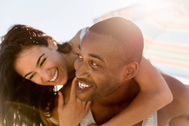 istock Happy man piggybacking girlfriend at beach 1127250522
