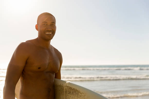 istock Thoughtful shirtless man with surfboard at beach 1127250539