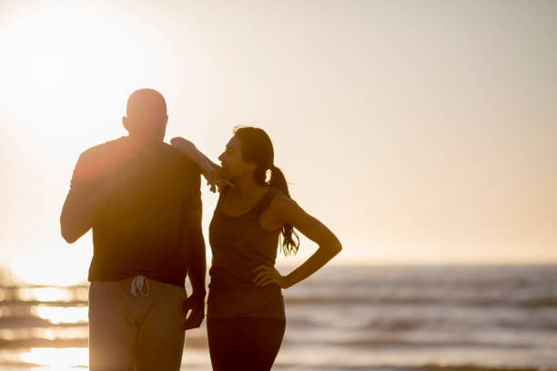 istock Fit couple standing at beach during sunset 1127250686