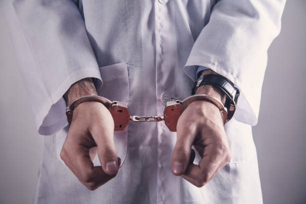 Doctor with handcuffs. Medical crime stock photo