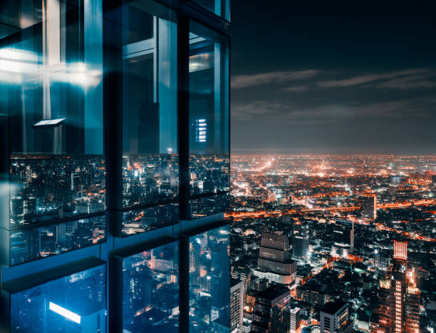 glass window with glowing crowded city - torre de alta imagens e fotografias de stock