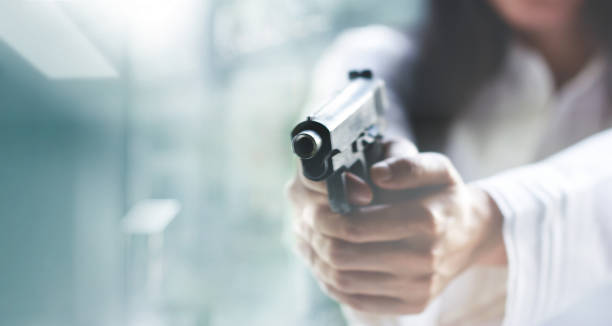 여자에 표적에 총을 가리키는 배경, 총 범죄, 전면 총에 선택적 초점 흐림. - hit man 뉴스 사진 이미지