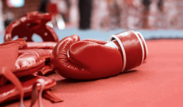 istock Red boxing gloves and boxing head guards for martial arts on pad background. 1127252964