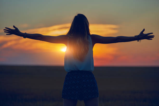 Cute young woman jumping in a wheat field.
