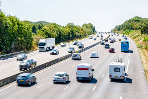 Heavy but fluid traffic on the A10 highway in France by a sunny day. Heavy but fluid traffic on the eight-lane A10 highway in France in the direction of Bordeaux by a hot summer day with cars, vans, trailers, buses and semitrailer truck driving. essonne stock pictures, royalty-free photos & images