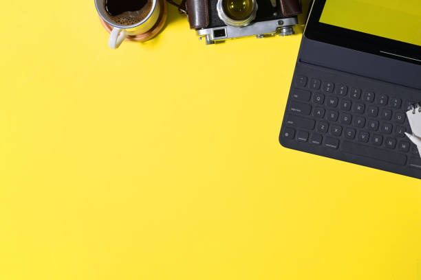 istock Top view creative yellow  desk with tablet, vintage camera and copy space 1127255959