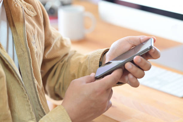 istock Cropped shot  of a man holding mockup mobile smart phone device on office workspace 1127255983