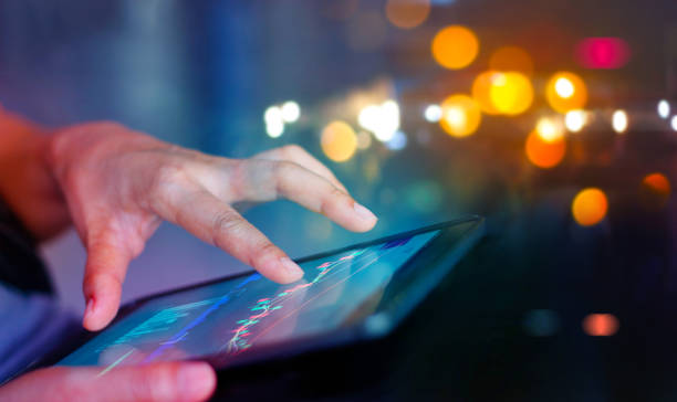 istock Stock market. Businessman using a mobile device to check market data and currency exchange rates on colorful background. 1127256103