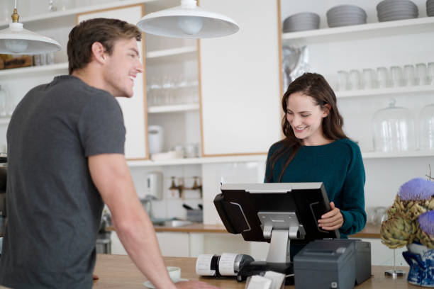 istock Smiling woman billing customer in coffee shop 1127258542