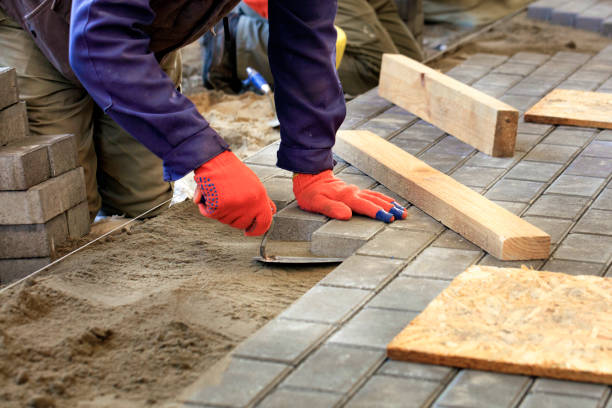 układanie płytek na chodniku, pracownik położyć płytkę, wyrównując ją na nitce - brickwork zdjęcia i obrazy z banku zdjęć