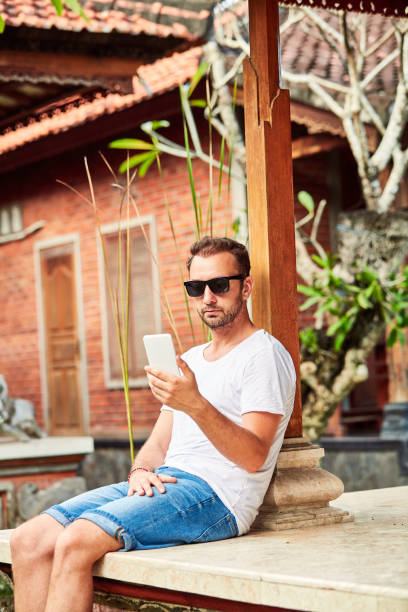 istock Man in summer shirt using smartphone. 1127259466