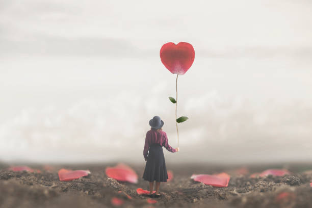 solitaria donna romantica tiene a cuore un petalo gigante fatto a cuore - romanticismo concetto foto e immagini stock