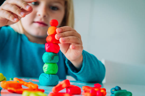 小さな女の子が形状を成形粘土で遊んで子供の工芸品 - shaping clay ストックフォトと画像