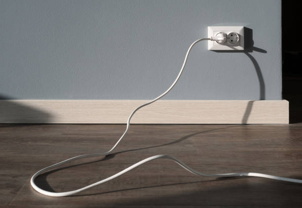 istock Power cord cable plugged into wall outlet 1127264172
