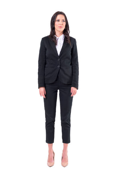 successful young pretty business woman in black suit standing with arms down looking away - arms at side imagens e fotografias de stock