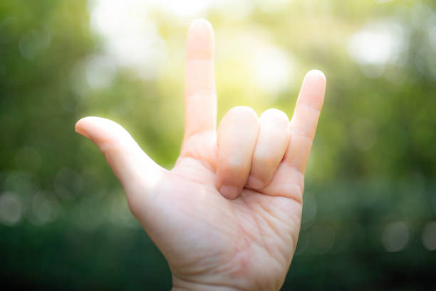 istock Love with the finger symbol Green tree bokeh as background.soft focus. 1127264322
