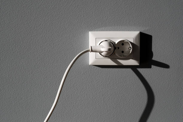 istock Power cord cable plugged into wall outlet 1127264371