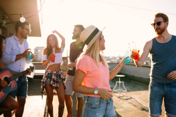 istock Group of happy friends having party on rooftop 1127264448
