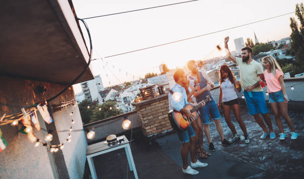 istock Group of happy friends having party on rooftop 1127264477