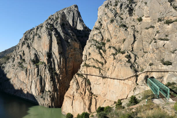 istock Hikers and train through El Chorro gorge 1127264481
