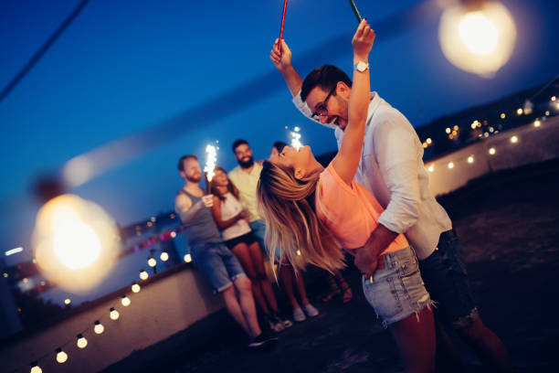 istock Group of happy friends celebrating at rooftop 1127264488