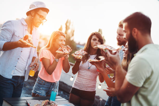 istock Group of happy friends having party on rooftop 1127264509