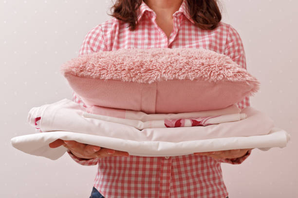 istock Woman holding a stack of clean ironing and a fur pillow 1127265561