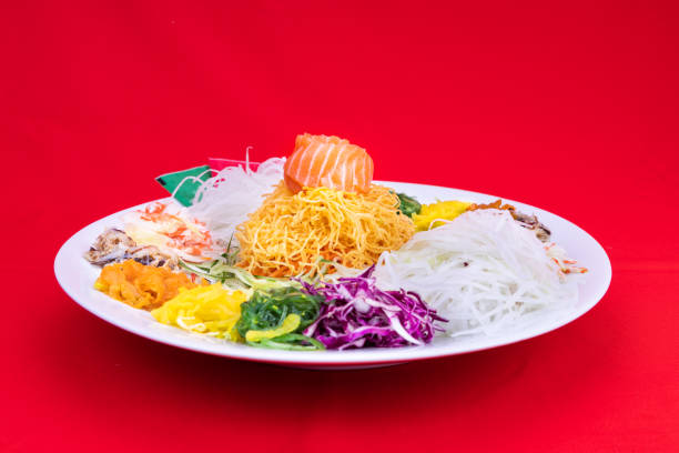 Serving of Yee Sang or Yusheng believed to bring luck Serving of Yee Sang or Yusheng believed to bring luck. Taken during Chinese New Year by tossing with chopsticks cantonese cuisine stock pictures, royalty-free photos & images