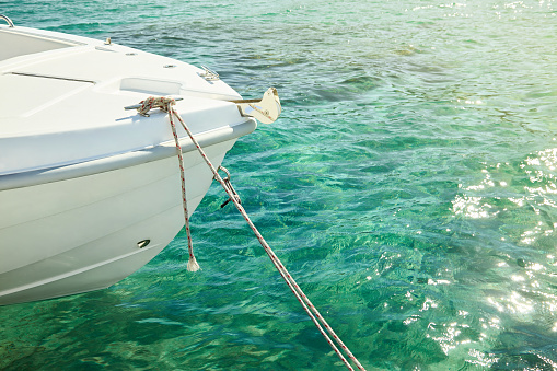 Motor boat in the sea tied up to the pier. Nobody is on the photo. Recreation concept