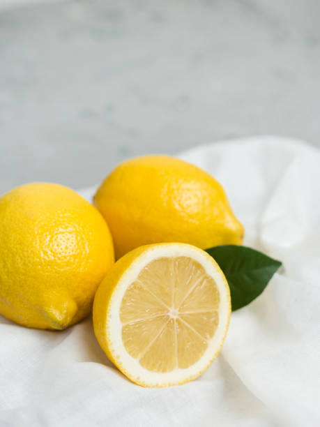 회색 배경에 흰색 패브릭과 걸 한 전체 및 슬라이스 레몬 유기농의 신선한 감귤 류의 과일, 복사 공간 - 유기농의 뉴스 사진 이미지