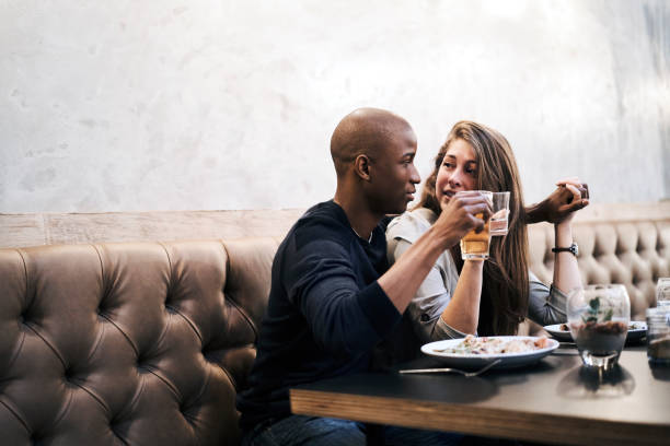 istock Couple with drinks holding hands in restaurant 1127272886