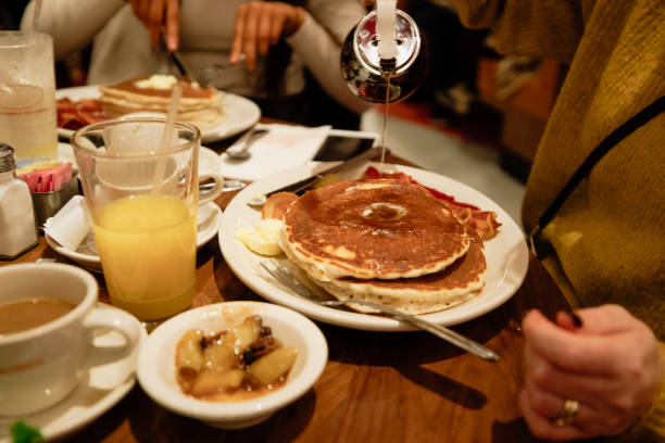 istock Pouring Syrup over Bacon and Pancakes 1127275482