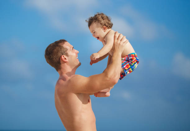 istock Young father with little son on tropical beach 1127275559