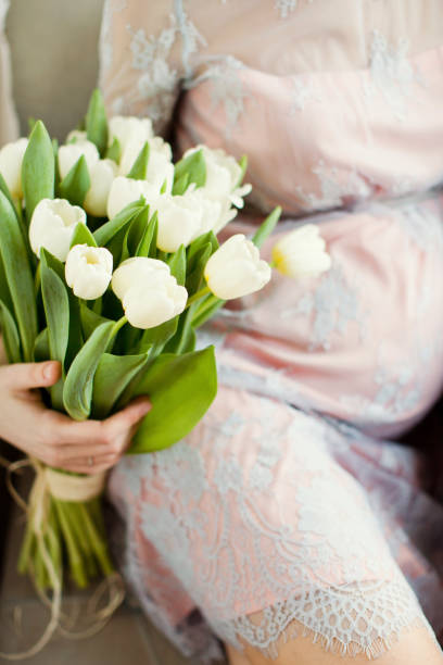 istock pregnant woman and white tulips 1127277285