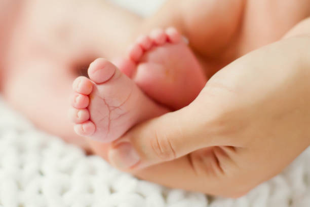istock mother holding baby feet 1127277397