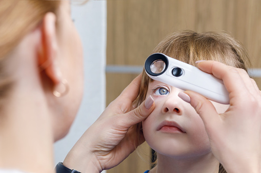 Un primer plano de un oftalmólogo comprobar el ojo de un niño. photo