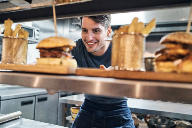 istock Smiling chef looking at food on kitchen counter 1127280813