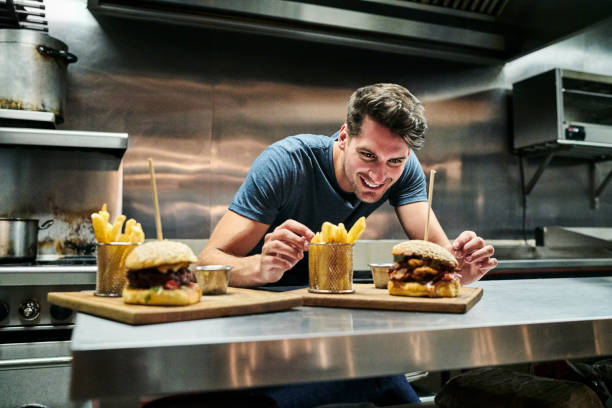 istock Smiling chef looking at food served on counter 1127281399