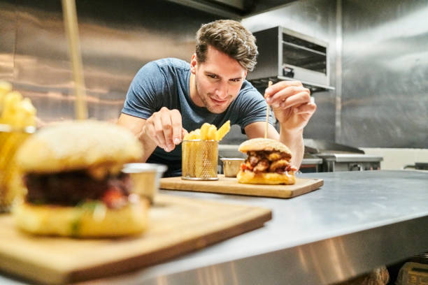 istock Smiling chef serving burger and French fries 1127282000