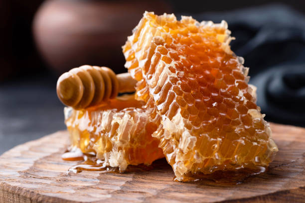 istock Honeycomb and honey dipper on wooden board 1127282569