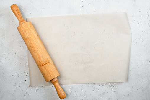 Rolling pin and baking paper background with copy space for text, recipe, menu. Baking or cooking food background