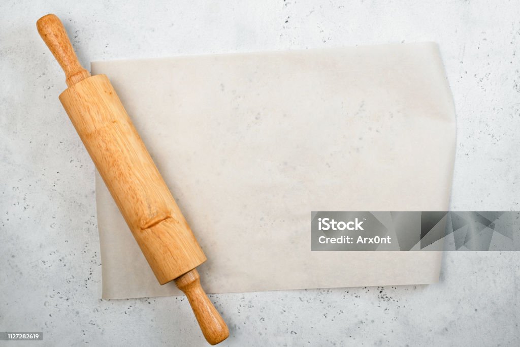 Rolling pin and baking paper background Rolling pin and baking paper background with copy space for text, recipe, menu. Baking or cooking food background Rolled Up Stock Photo