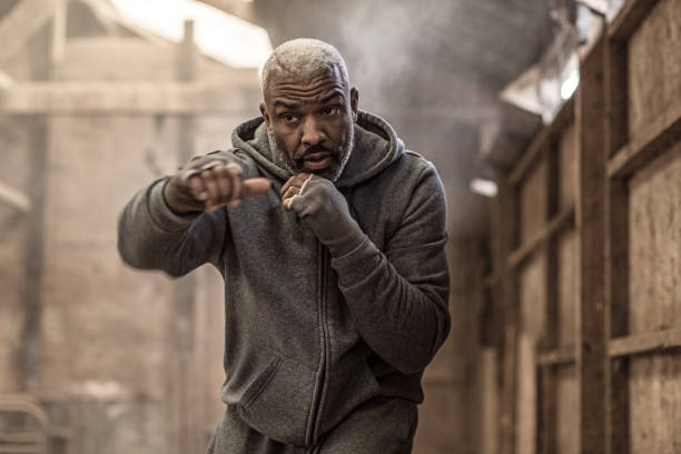 istock Middle aged black fighter working out in an abandoned farm 1127283503