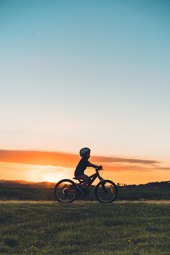 Kid enjoying outdoor on his bike during sunset in Auckland, New Zealand.