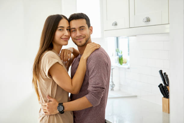 istock Smiling young couple embracing in kitchen 1127284804
