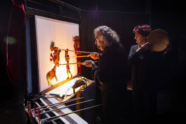 Traditional Turkish shadow play Karagoz and Hacivat Backstage view of a traditional Turkish shadow play Karagoz and Hacivat. Shadow puppet master and his assistant on show. hacivat karagoz stock pictures, royalty-free photos & images
