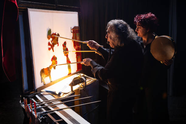Traditional Turkish shadow play Karagoz and Hacivat Backstage view of a traditional Turkish shadow play Karagoz and Hacivat. Shadow puppet master and his assistant on show. hacivat karagoz stock pictures, royalty-free photos & images
